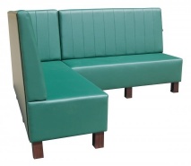 Zielona sofa narożna na drewnianych nogach